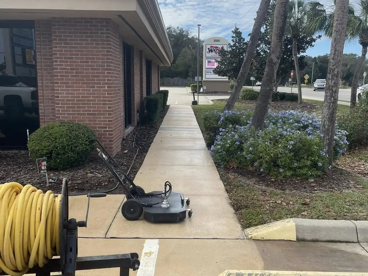 Commercial entry walkway cleaned with the pressure washing rig staged alongside