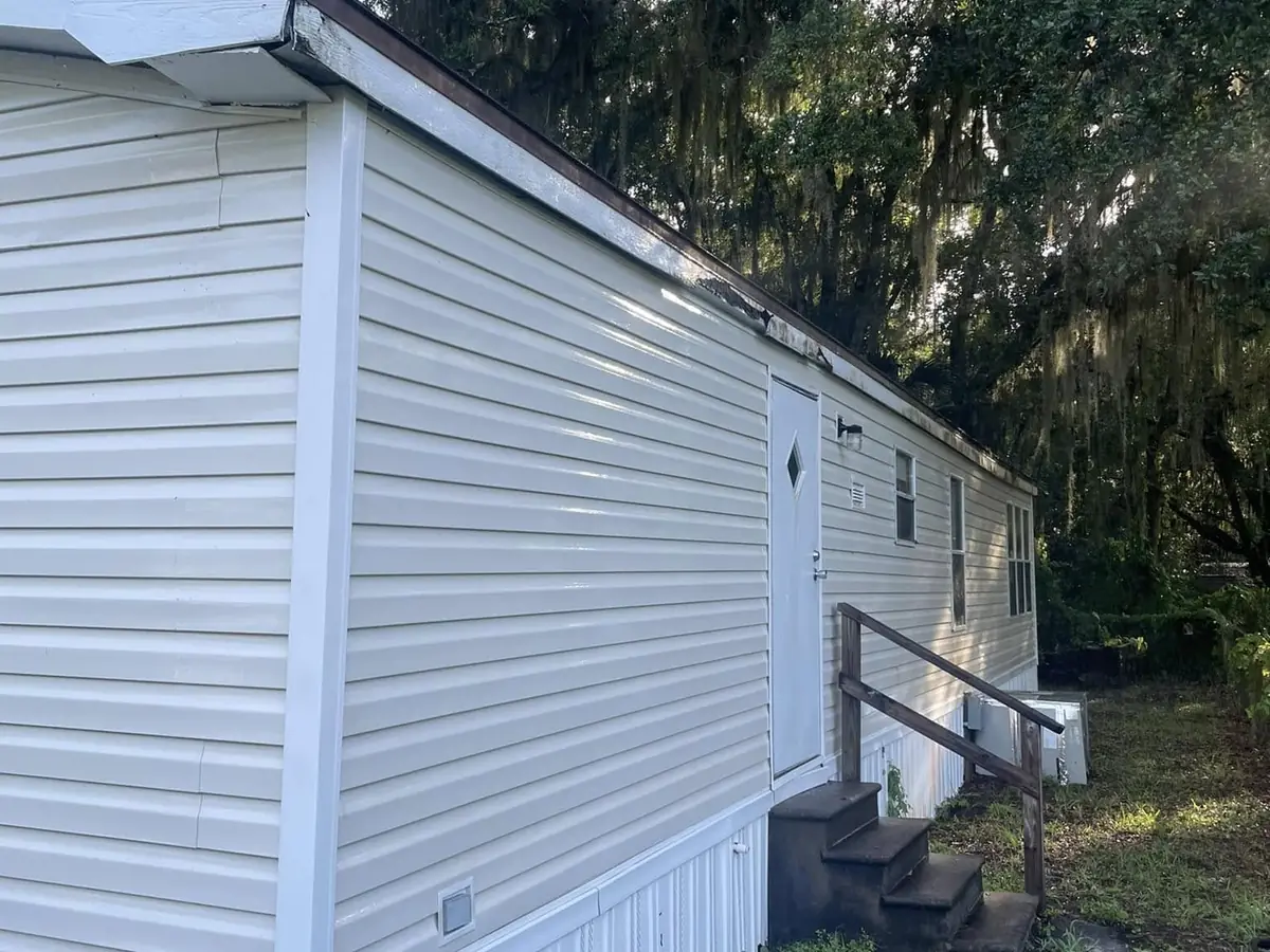The same home siding cleaned back to its original colour