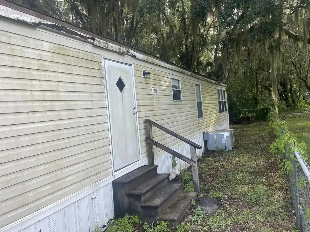 Weathered home siding streaked with mildew before a soft wash